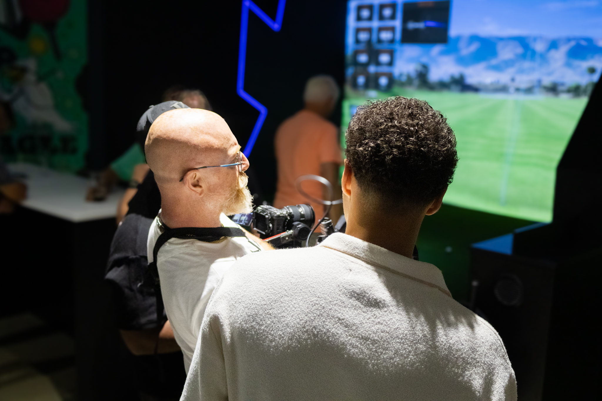 A crew producing content inside an indoor golf simulator venue
